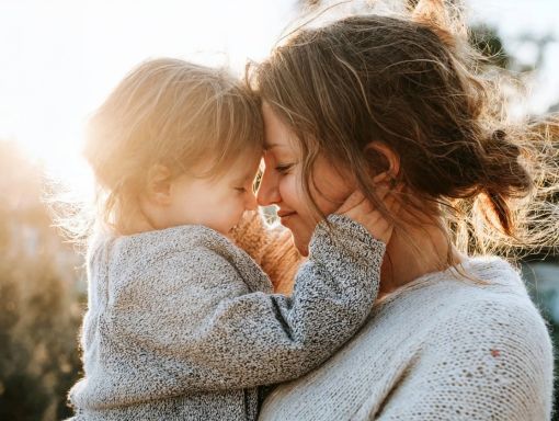 Mother and child face to face in a tender sunset moment, the kind of present, regulated parenting that 1-to-1 coaching builds