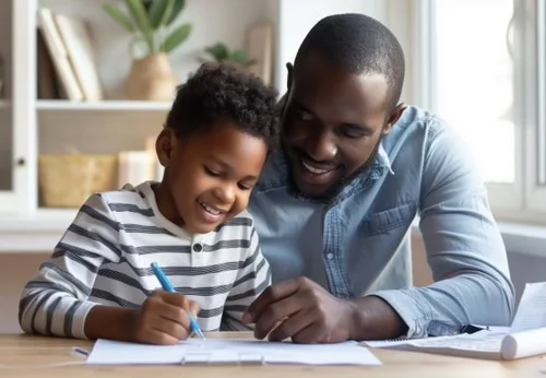 Father and child connected at a table, the kind of present, calm co-parenting that classes help protect